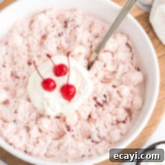 Crimson Cloud 8 Close up photo of a bowl of Cherry Fluff topped with cool whip and maraschino cherries