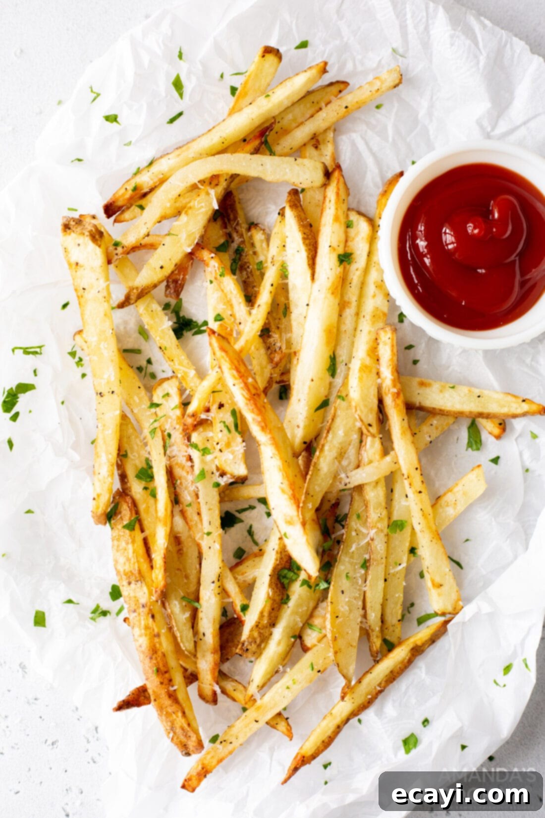 Perfectly Crispy Air Fryer Fries 2 Crispy air fryer french fries served on a plate with a side of ketchup, garnished with fresh parsley.