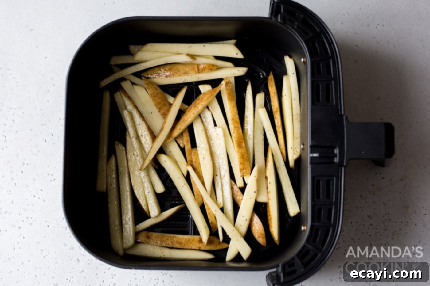 Perfectly Crispy Air Fryer Fries 7 Seasoned potato slices placed in a single layer in an air fryer basket, ready for cooking.