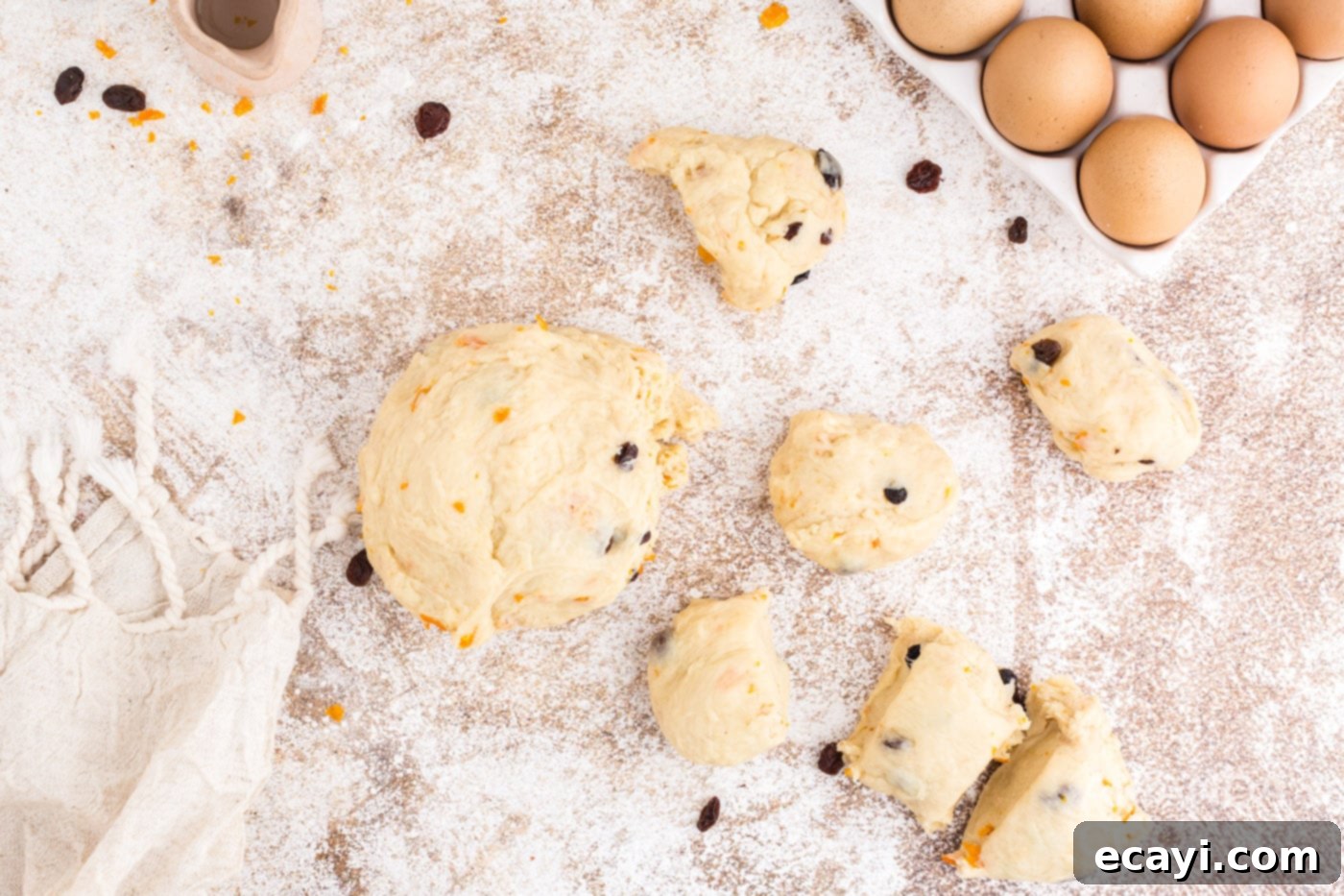 Spiced Easter Buns 13 Dough divided into 12 equal pieces on a floured surface, covered and resting.