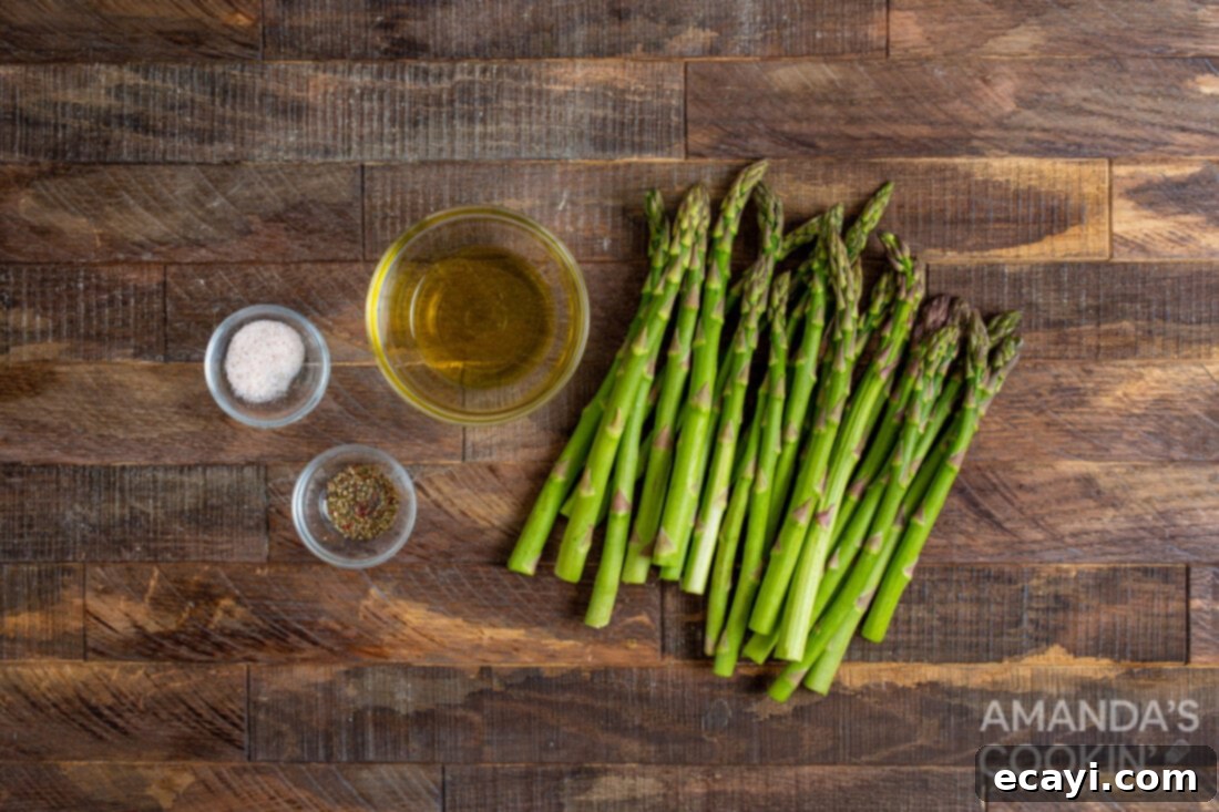 Crispy Air-Fried Asparagus 4 ingredients for Air Fryer Asparagus laid out on a cutting board, including fresh asparagus, olive oil, salt, and pepper
