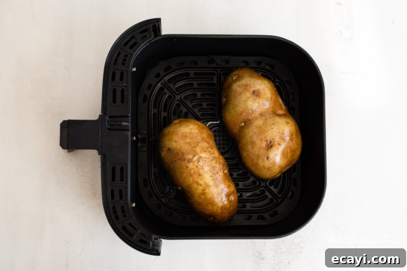 Perfect Air Fryer Baked Potatoes 5 russet potatoes in an air fryer basket