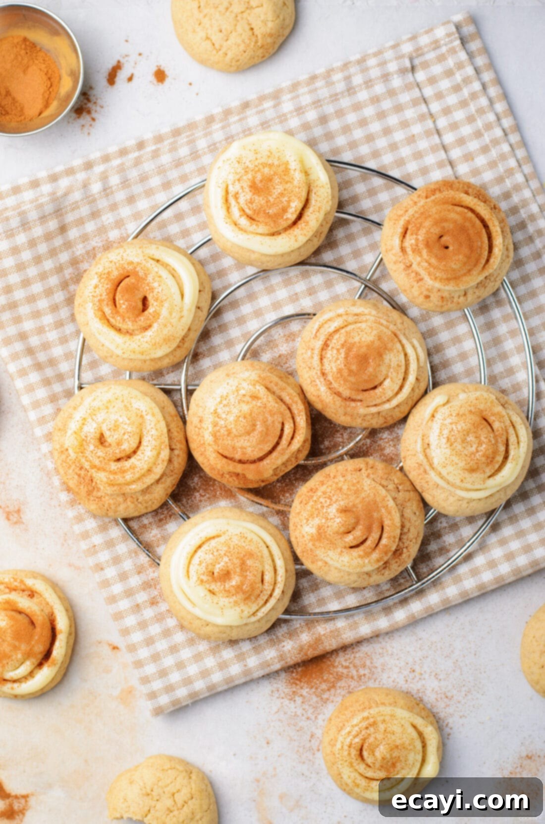 Cinnamon Swirl Delights 10 Freshly baked cinnamon roll cookies with cream cheese frosting cooling on a wire rack, ready to be enjoyed.