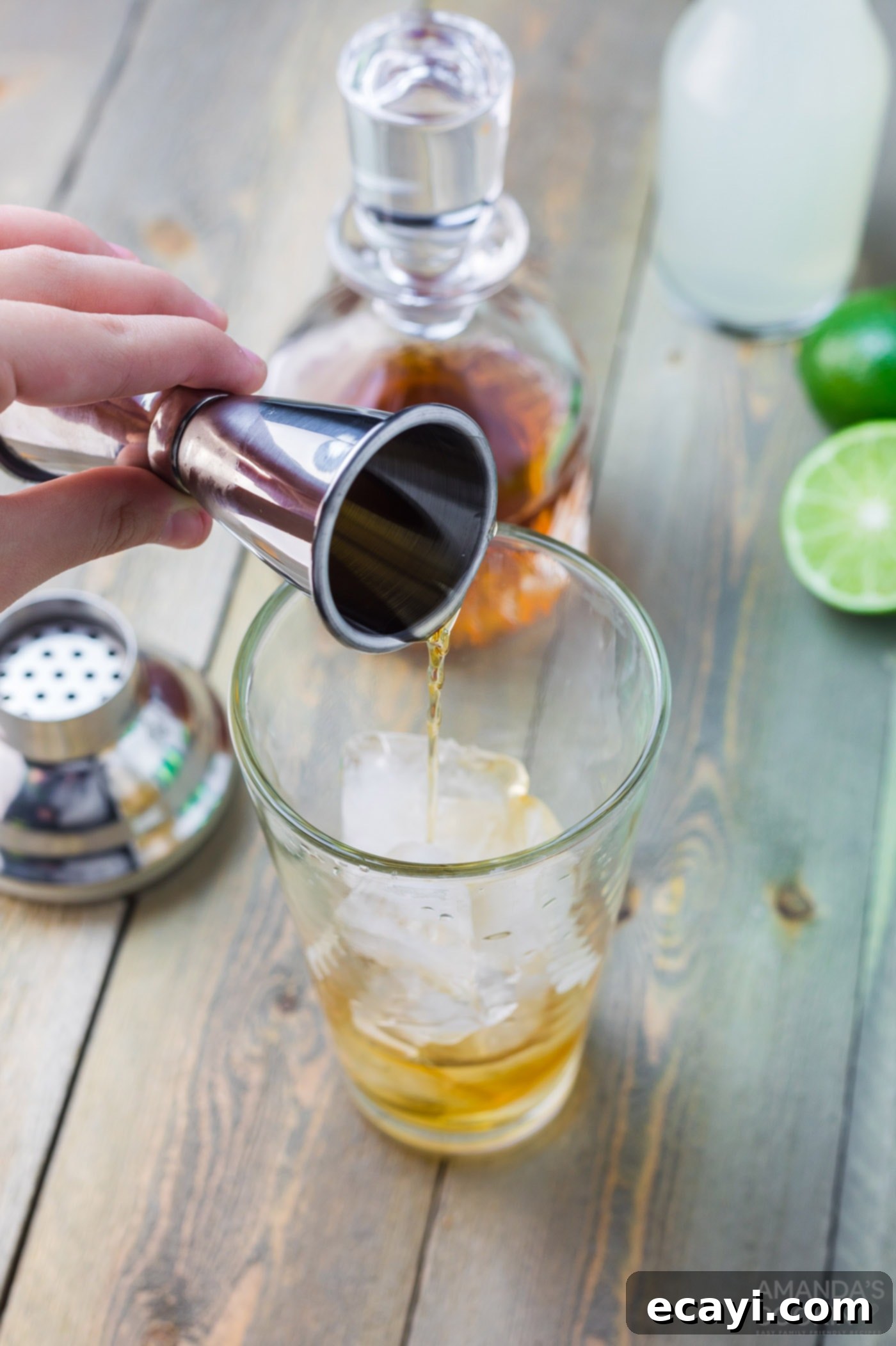 Boozy Limeade 5 adding whiskey to a highball glass