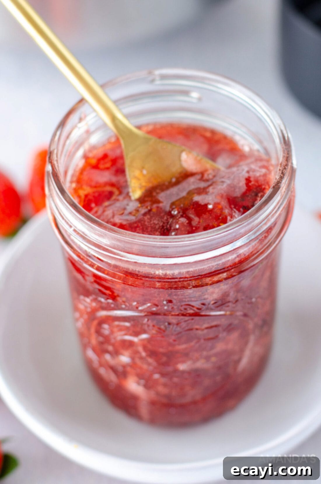 Homemade Strawberry Bliss 2 Jar of Homemade Strawberry Jam with a spoon in it, showcasing its rich red color and chunky texture