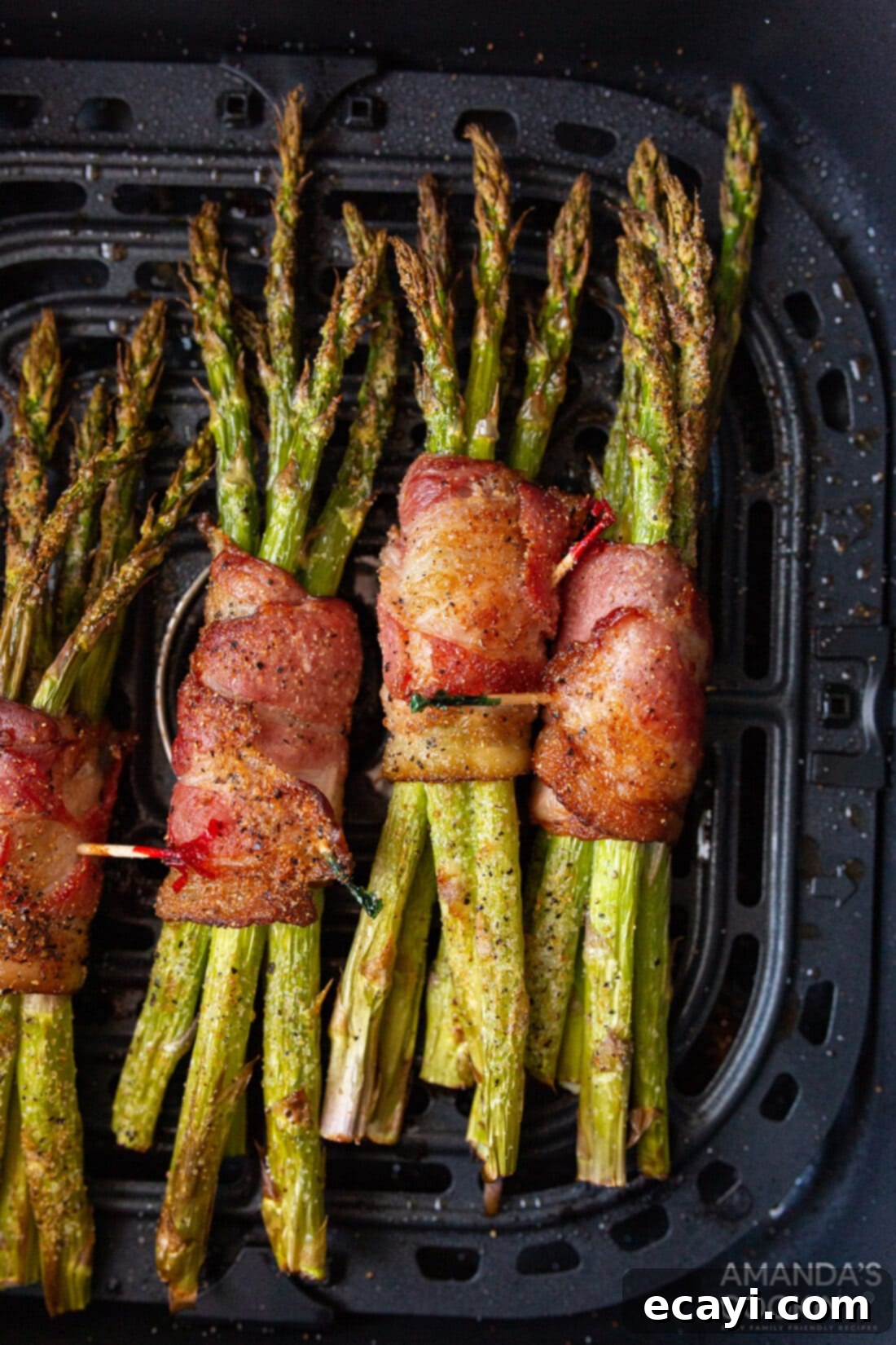 Crispy Air Fryer Bacon Asparagus Bundles 3 Bacon Wrapped Asparagus in an air fryer basket