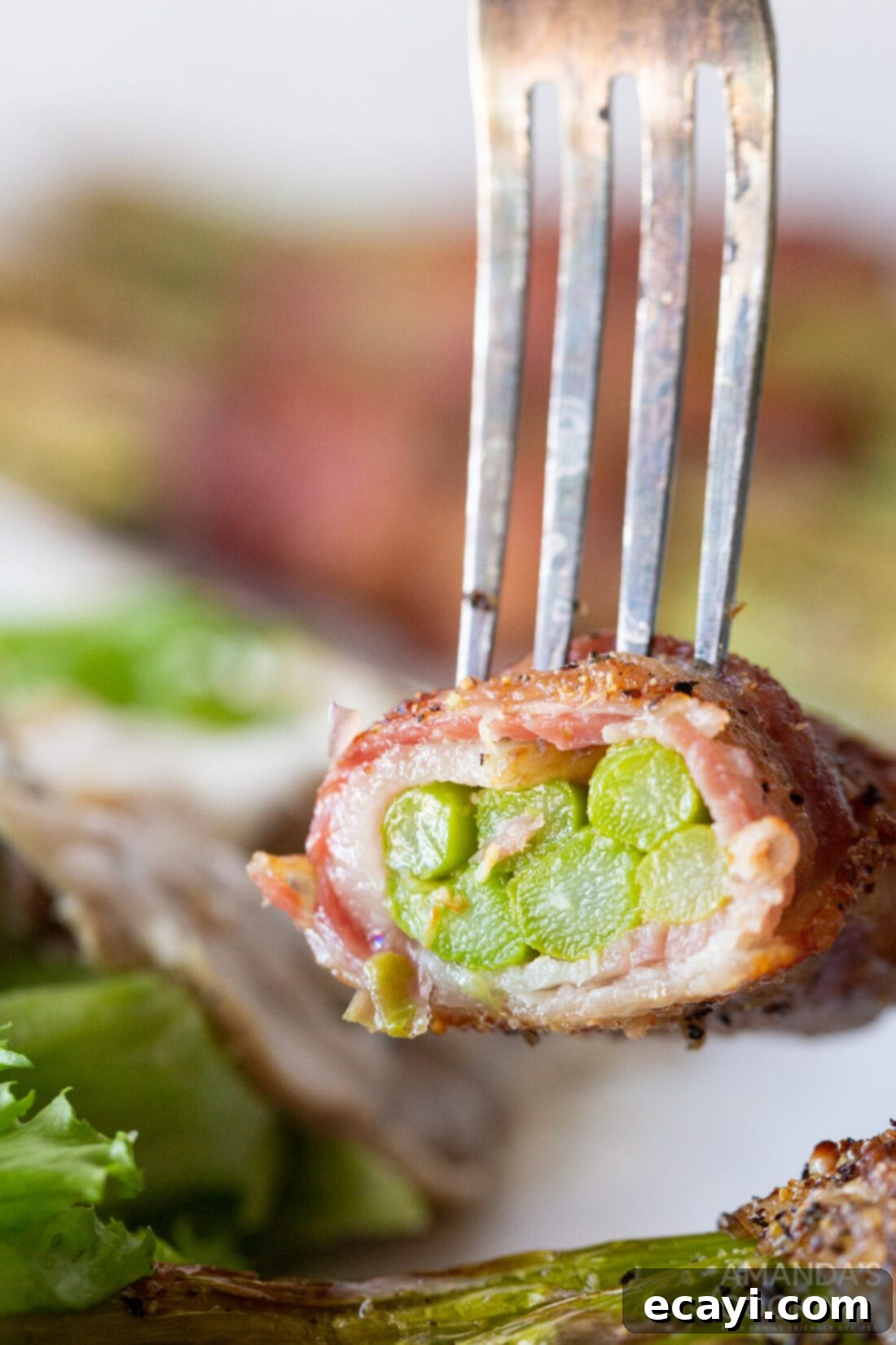 Crispy Air Fryer Bacon Asparagus Bundles 5 fork full of cut Bacon Wrapped Asparagus