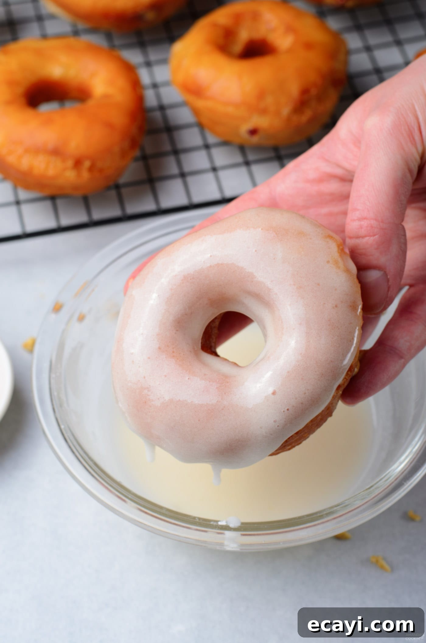 Peanut Butter and Jelly Donut Perfection 13 A freshly glazed donut being dipped into a sweet white glaze, ready for topping