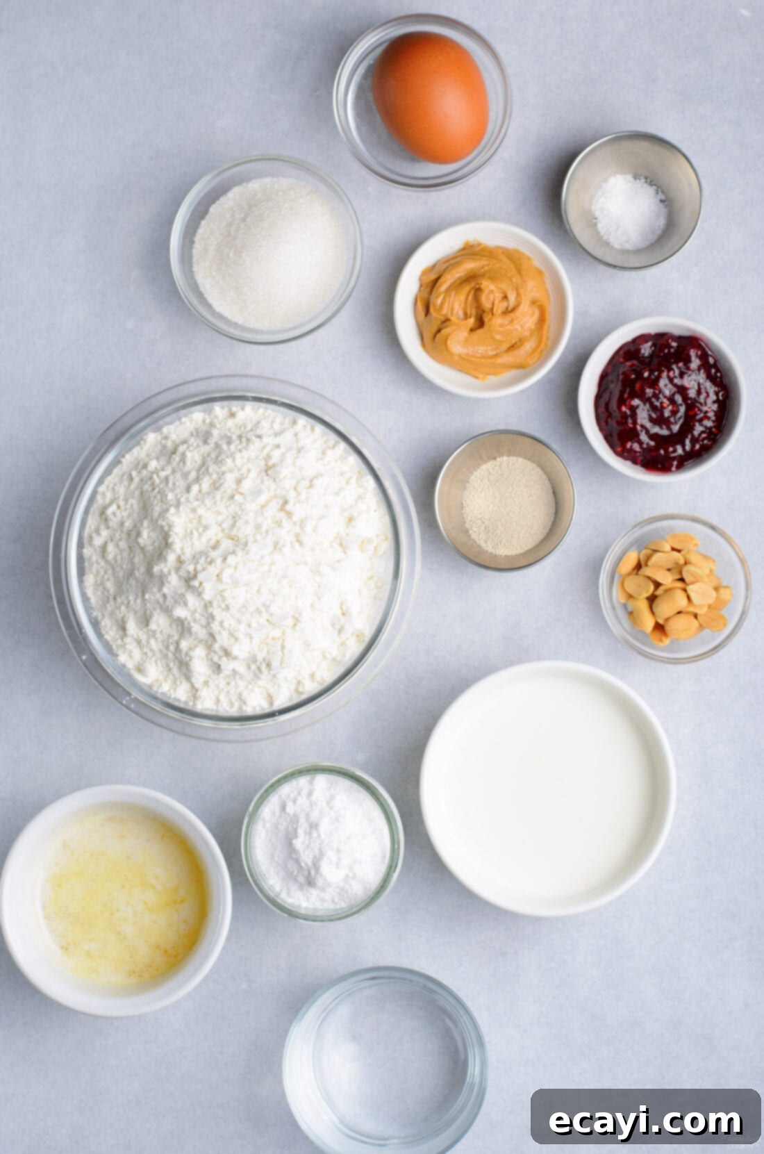 Peanut Butter and Jelly Donut Perfection 4 A collection of ingredients laid out for making homemade donuts, including flour, butter, eggs, and various baking components.