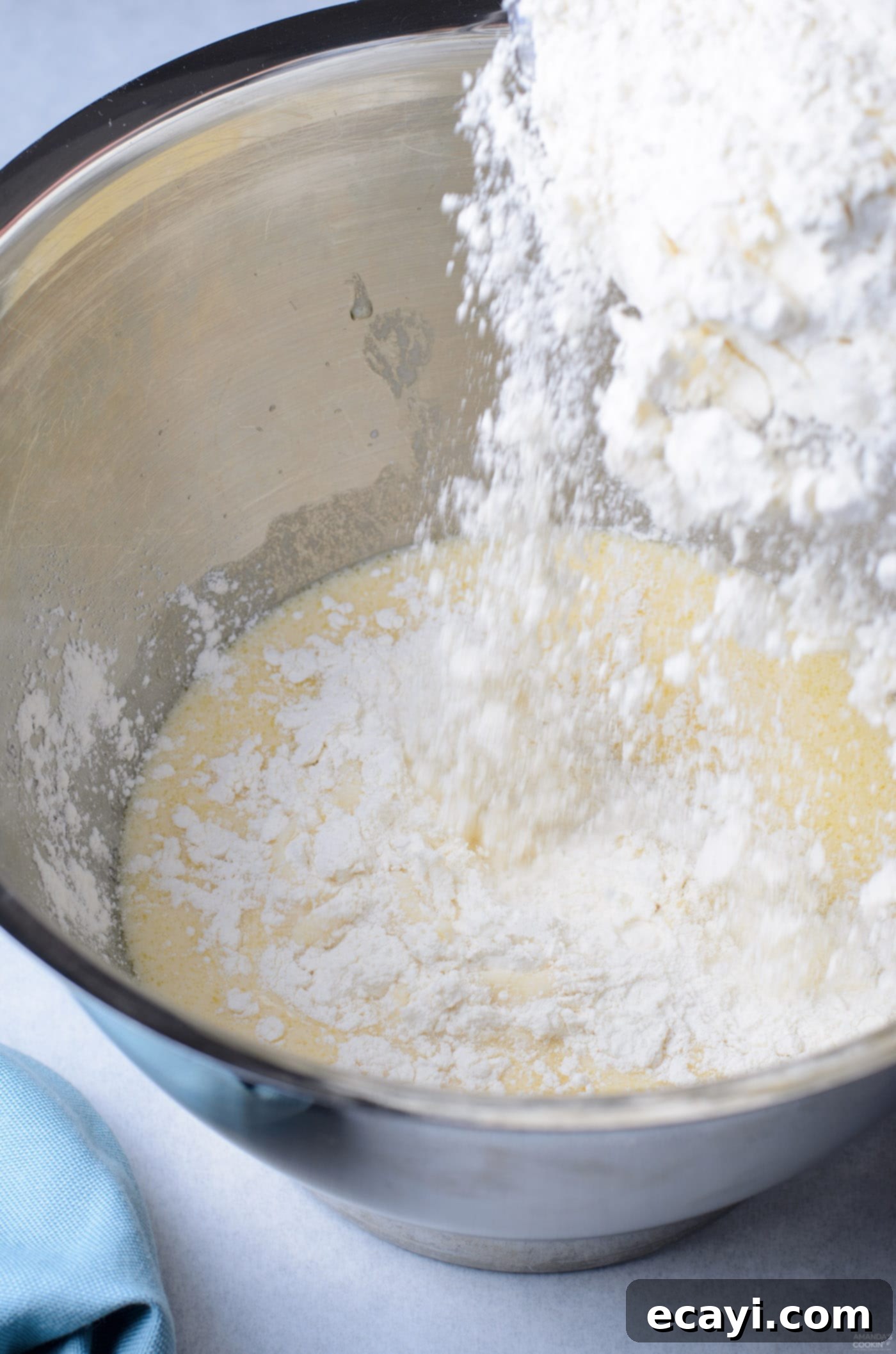 Peanut Butter and Jelly Donut Perfection 5 Pouring all-purpose flour into a bowl with yeast mixture, starting the donut dough