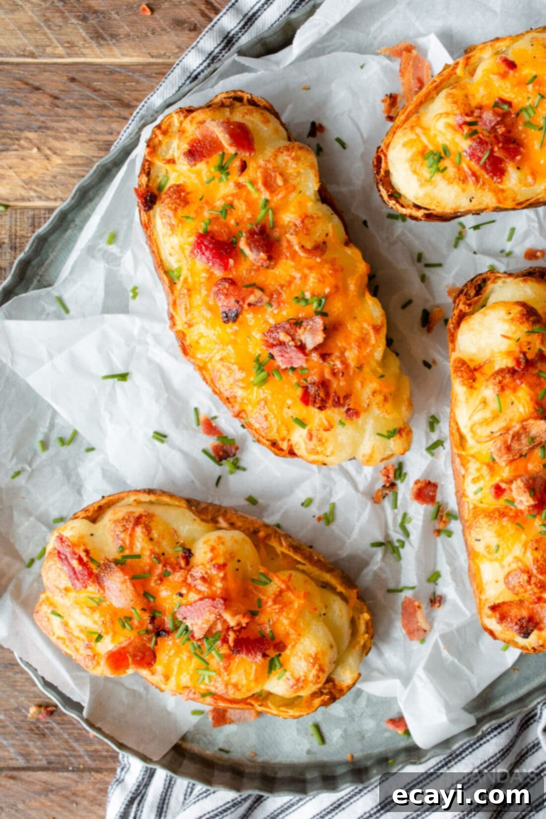 Golden Crispy Air Fryer Twice Baked Potatoes 2 Air Fryer Twice Baked Potatoes on parchment paper, showcasing golden brown perfection