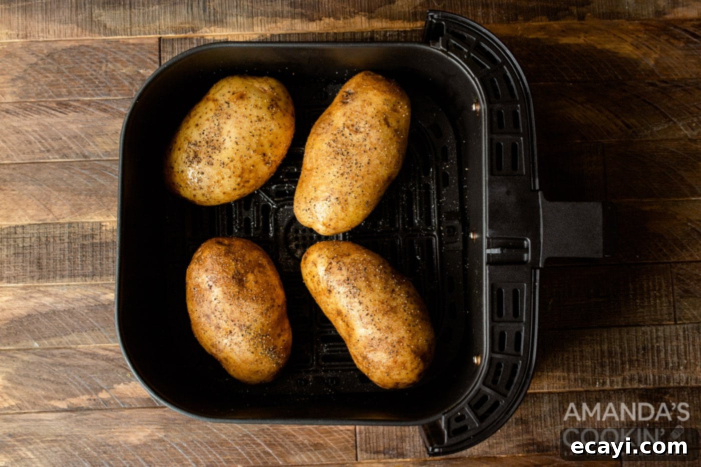 Golden Crispy Air Fryer Twice Baked Potatoes 5 Russet potatoes seasoned with olive oil, salt, and pepper, placed in an air fryer basket for the first bake