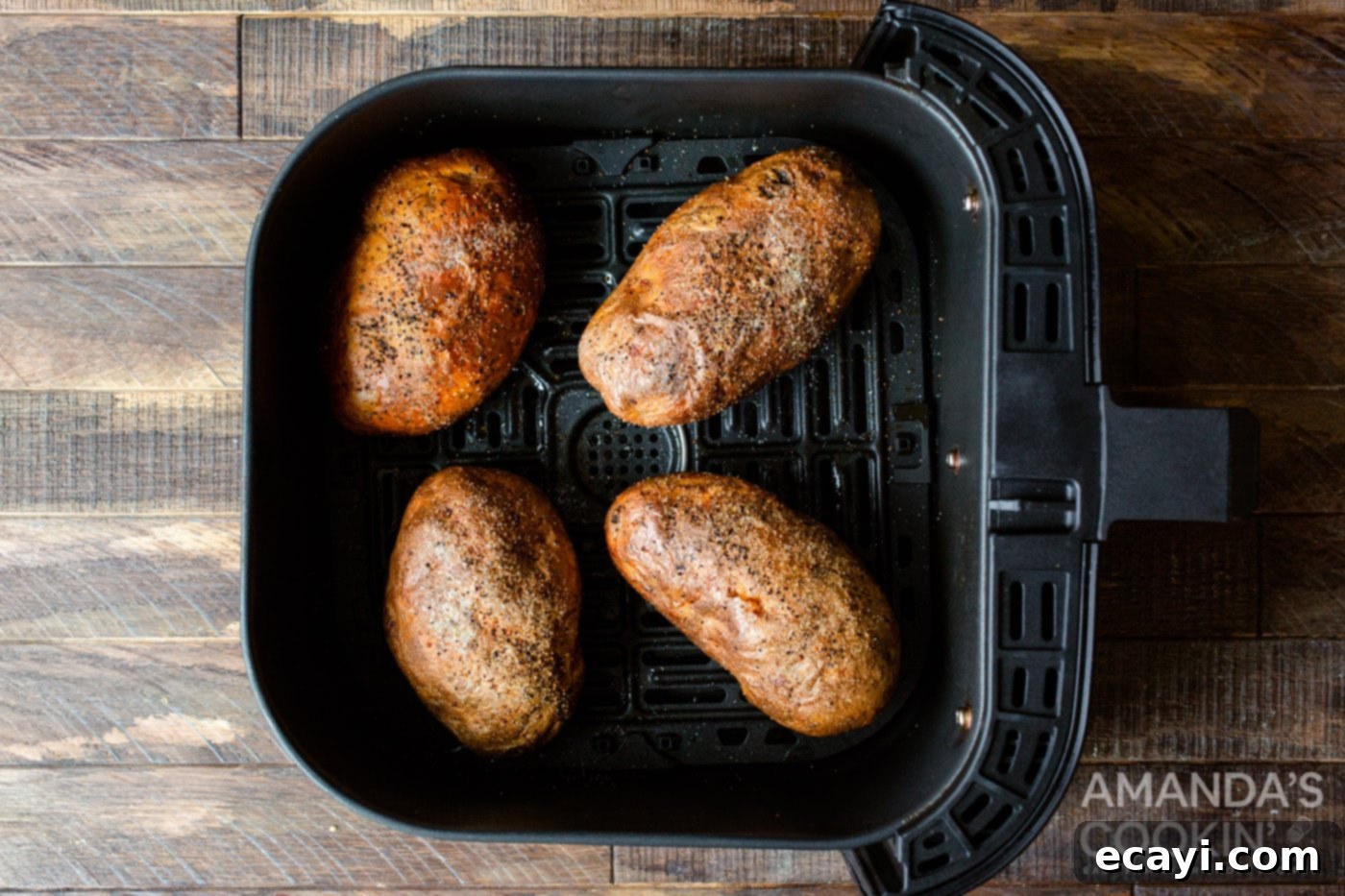 Golden Crispy Air Fryer Twice Baked Potatoes 6 Perfectly cooked russet potatoes, with crispy skins, removed from the air fryer basket after the initial bake