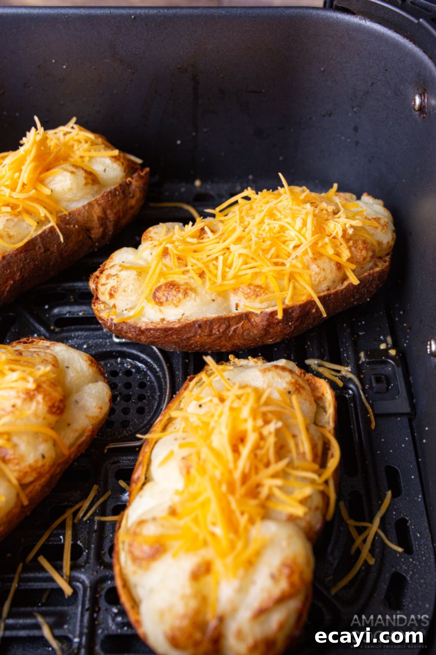 Golden Crispy Air Fryer Twice Baked Potatoes 10 Finished twice baked potatoes, loaded with melted cheese and crispy bacon, in an air fryer basket