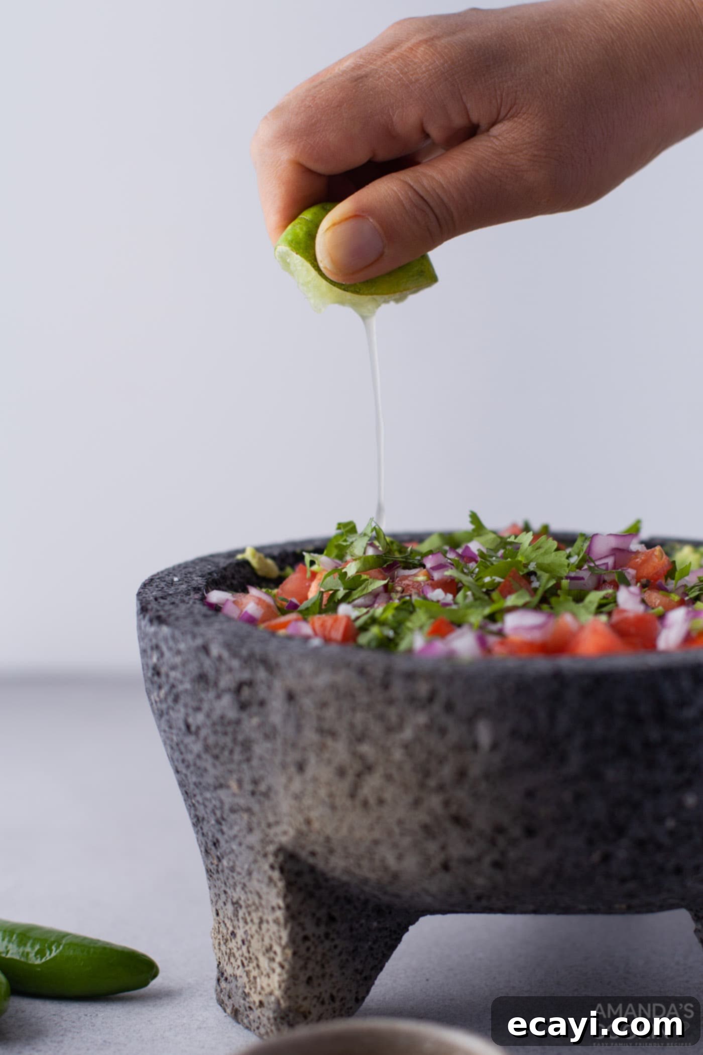 Guacamole 7 hand squeezing lemon into guacamole