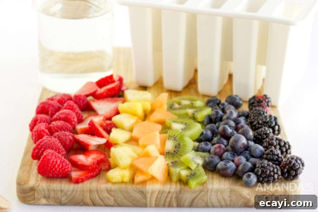 Refreshing Fruit Treats 4 Close-up of freshly chopped colorful fruits like strawberries, kiwi, pineapple, and berries on a wooden cutting board, ready for popsicle making.