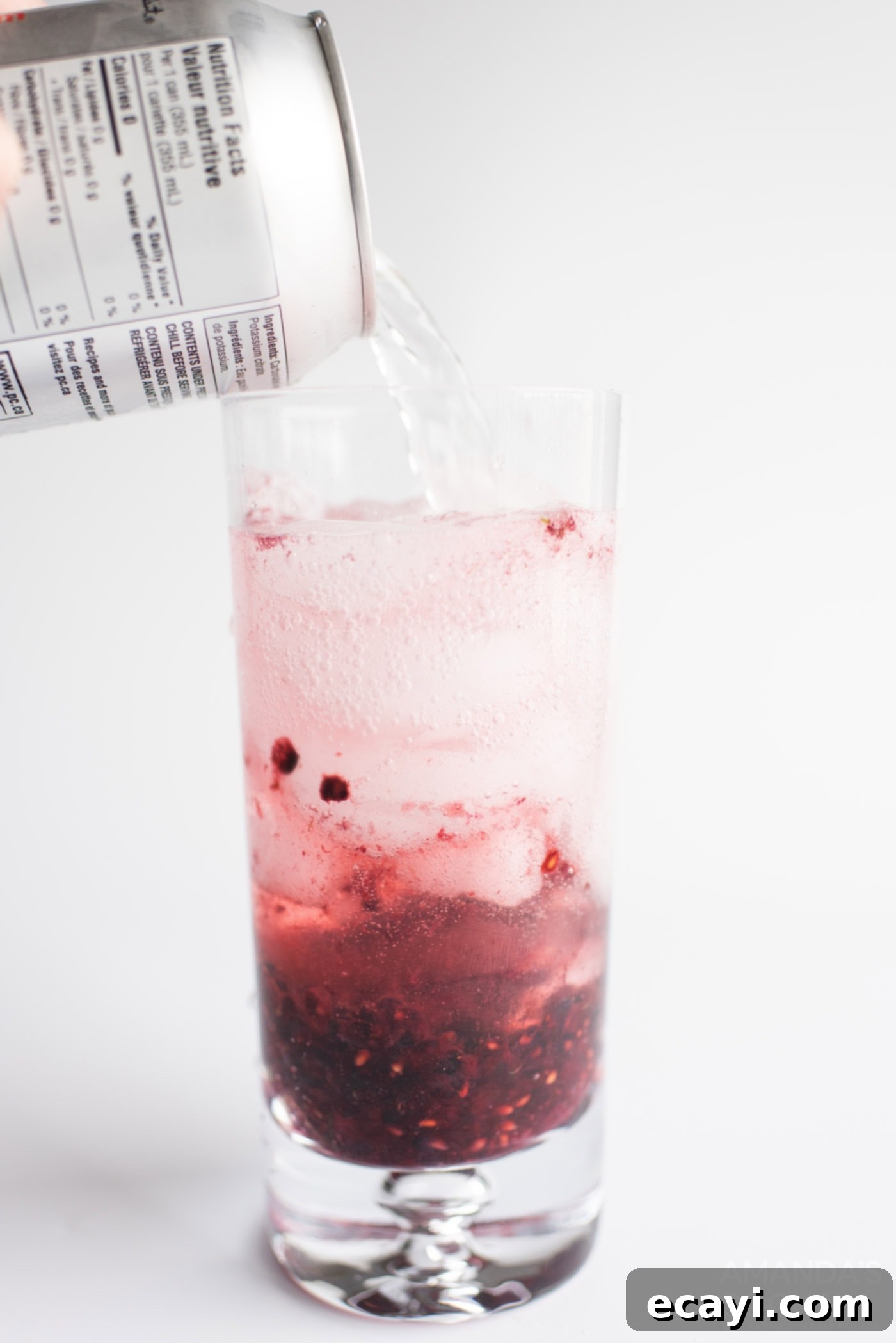 Midnight Berry Mojito 7 Topping off a glass of blackberry mojito with sparkling club soda, showing the fizz and vibrant color