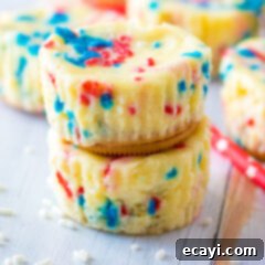 Stars and Stripes Cheesecake Bites 9 Close up photo of a stack of two Patriotic Mini Cheesecakes, garnished with whipped cream and sprinkles.