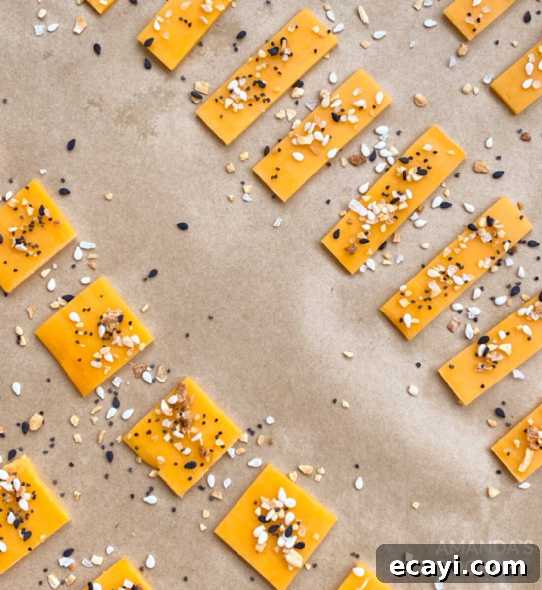 Crunchy Keto Cheese Bites 4 Slices of cheddar cheese neatly arranged, with a small pile of 'Everything Bagel' seasoning beside them, ready for making keto crackers.