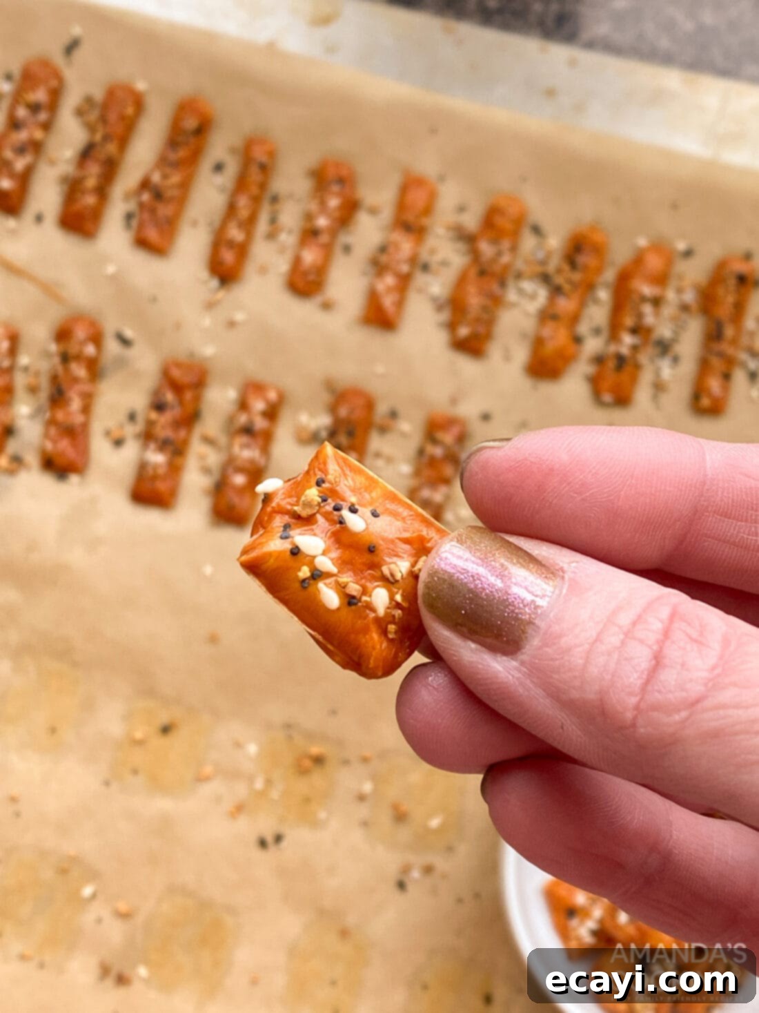 Crunchy Keto Cheese Bites 8 A hand holding a single golden, crispy keto cheese cracker, showing its texture and inviting appearance.