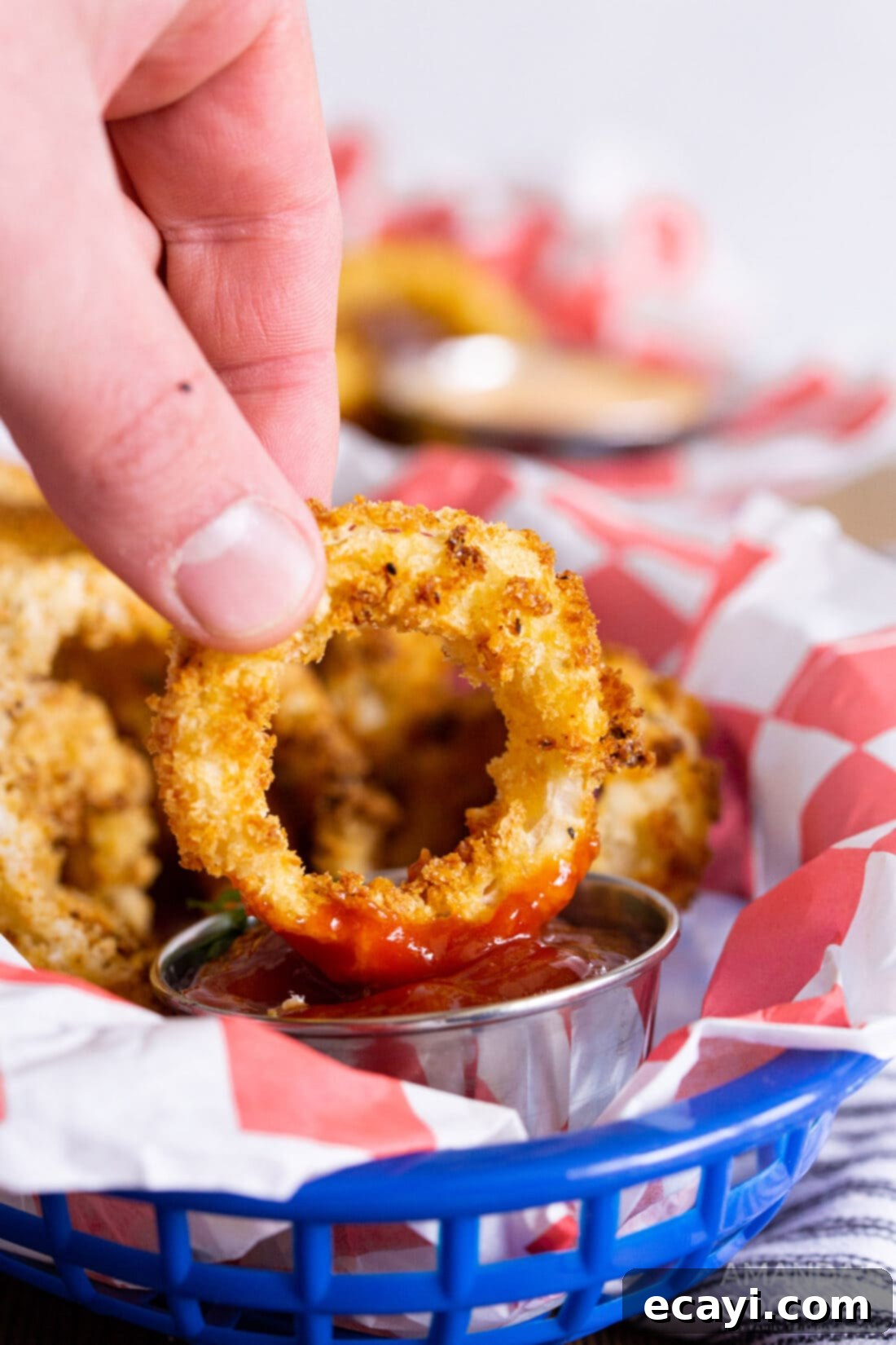 Golden Air Fryer Onion Rings 3 Dipping a crispy air fryer onion ring in ketchup