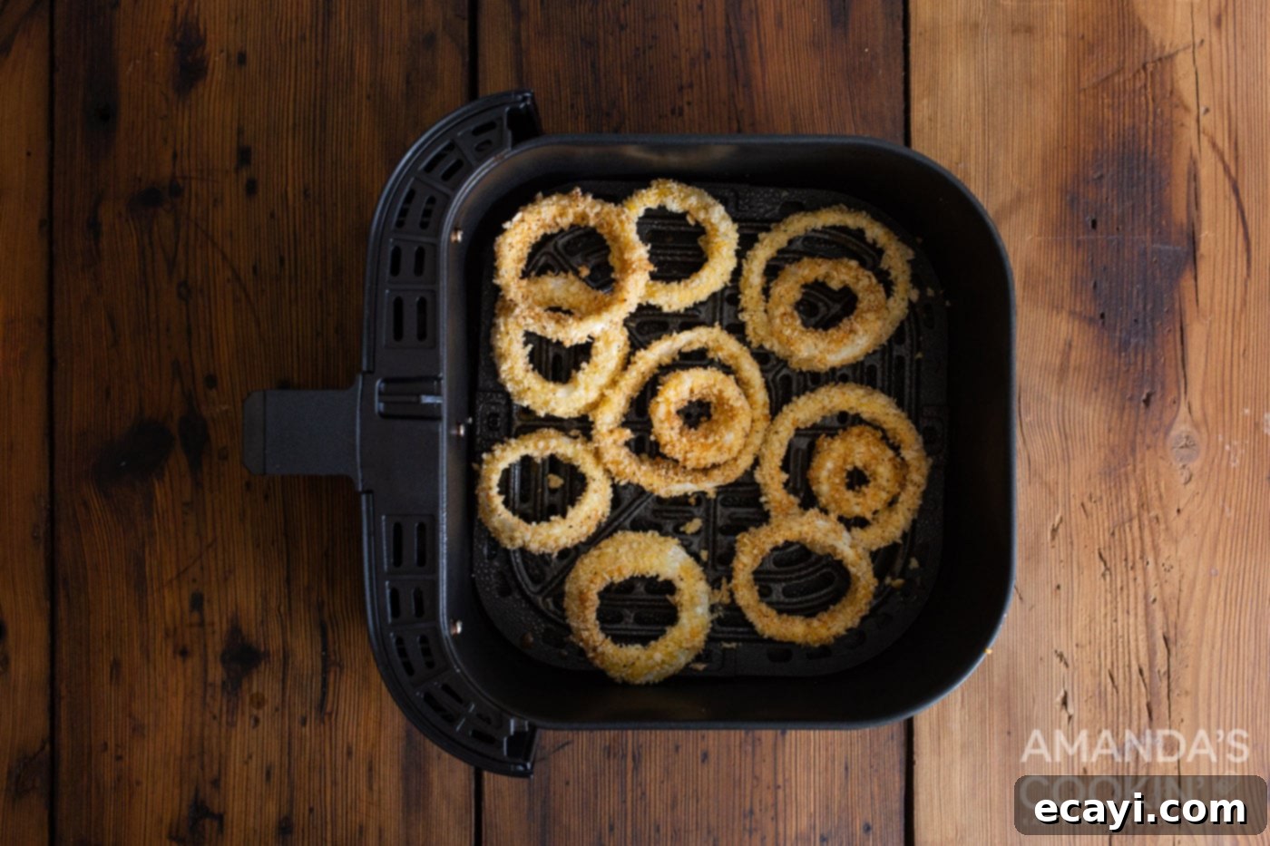 Golden Air Fryer Onion Rings 7 Breaded onion rings cooking in the air fryer basket