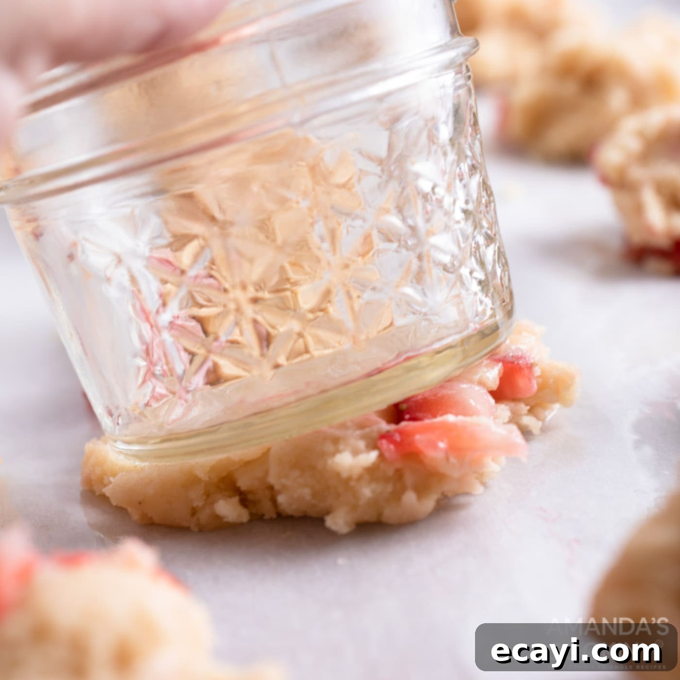 Zesty Strawberry Lemonade Cookies 11 Flattening scooped cookie dough balls with the bottom of a mason jar for even thickness.