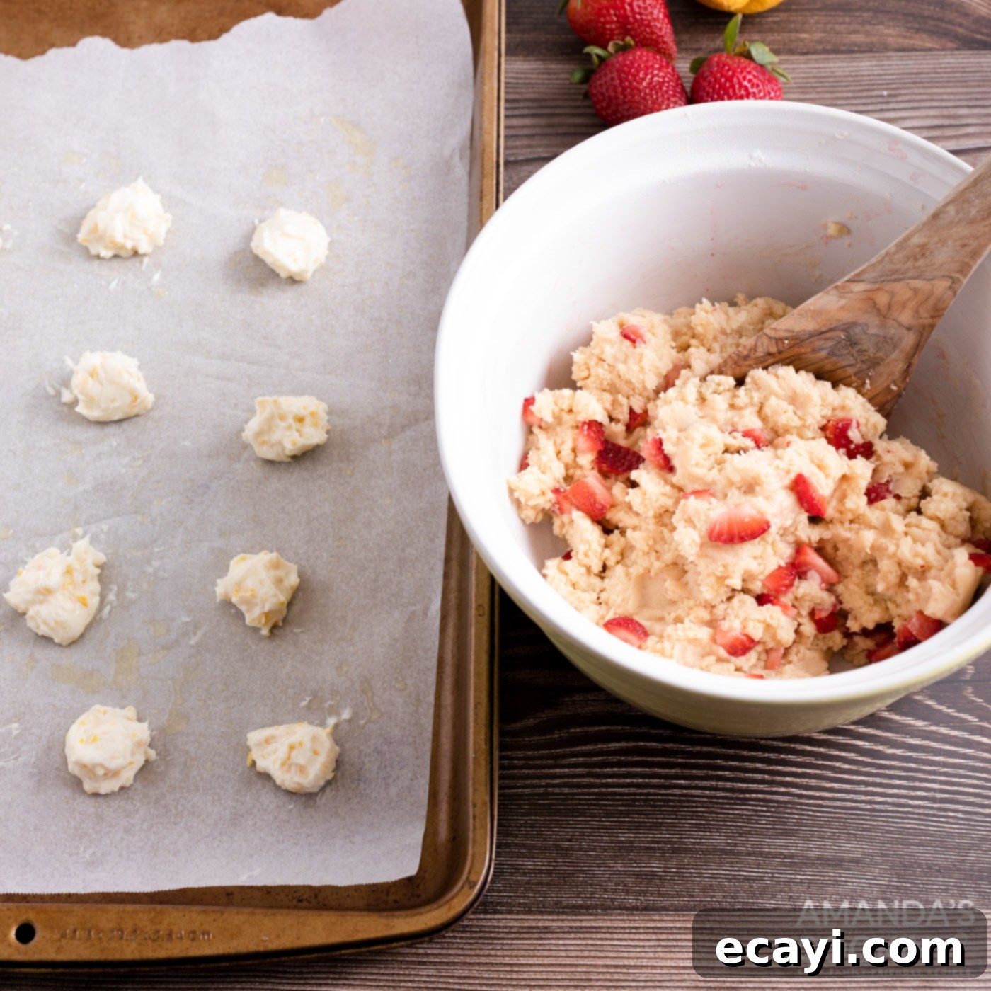 Zesty Strawberry Lemonade Cookies 9 Small cream cheese balls arranged on a baking sheet next to a bowl of strawberry cookie dough.