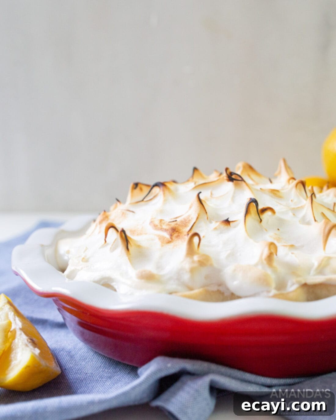 Lemon Meringue Pie 3 A freshly baked lemon meringue pie with intricate swirls and golden-brown peaks on the meringue topping.