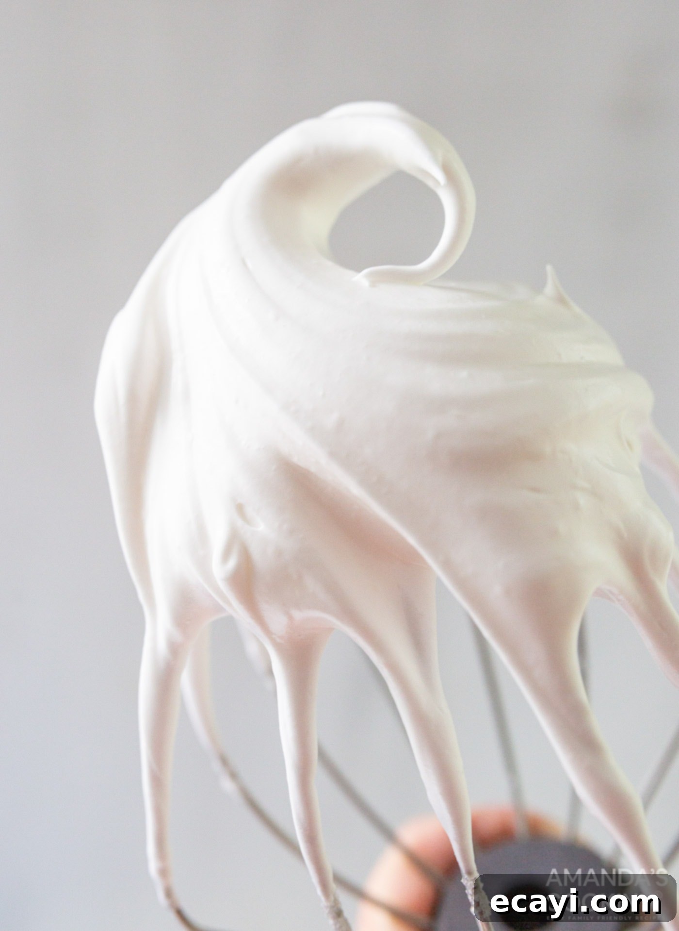 Lemon Meringue Pie 8 A whisk with fluffy white meringue, showcasing the stiff peaks.