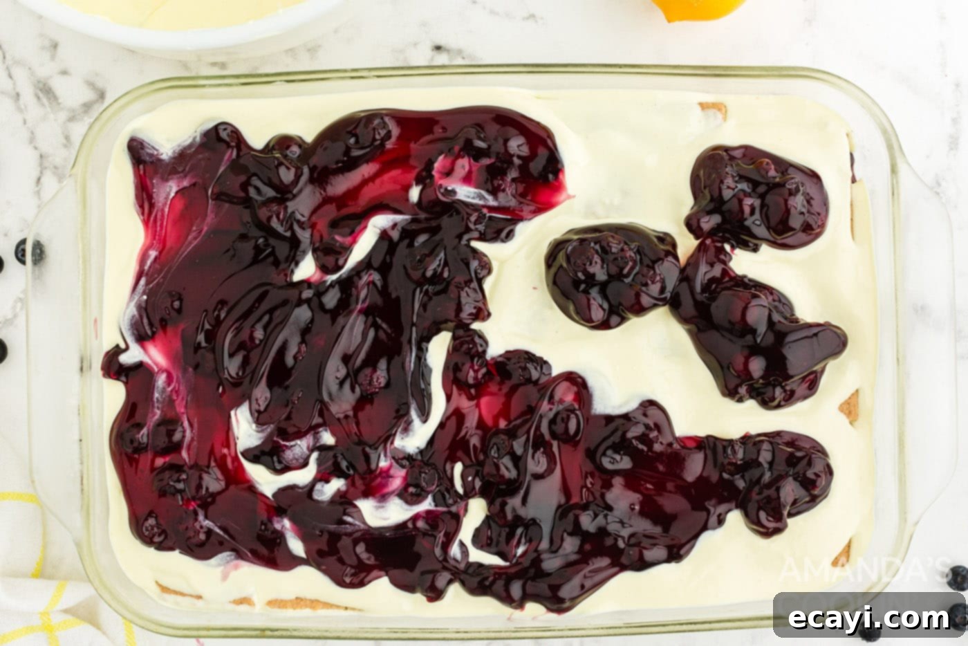Zesty Lemon Blueberry Cloud Cake 11 Another layer of blueberry pie filling spread on top of a pudding layer in the casserole dish.