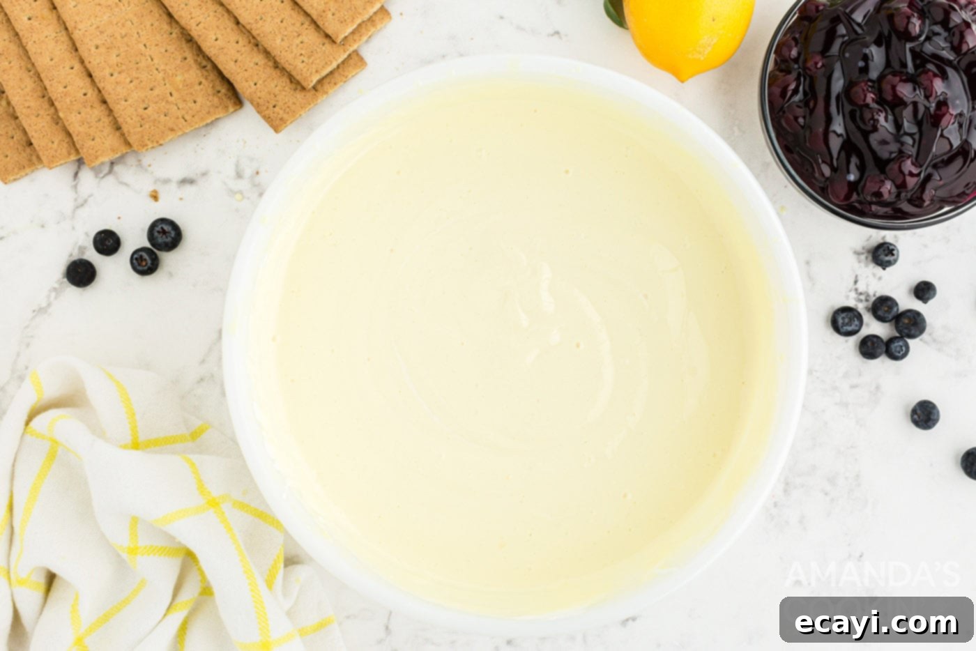 Zesty Lemon Blueberry Cloud Cake 6 The smooth and thick lemon pudding mixture with Cool Whip in a mixing bowl.