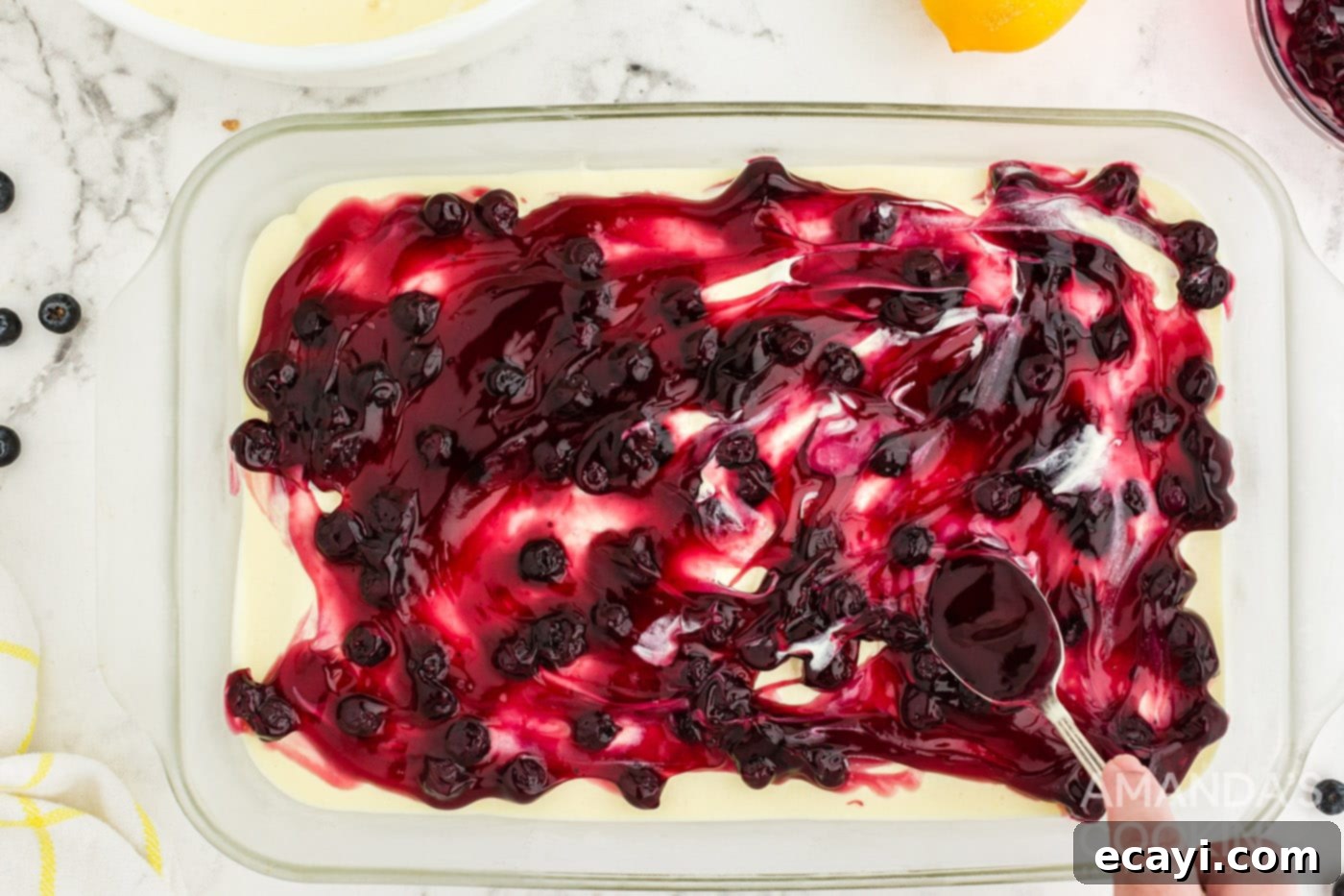 Zesty Lemon Blueberry Cloud Cake 8 Spreading a rich layer of blueberry pie filling over the lemon pudding layer in the casserole dish.