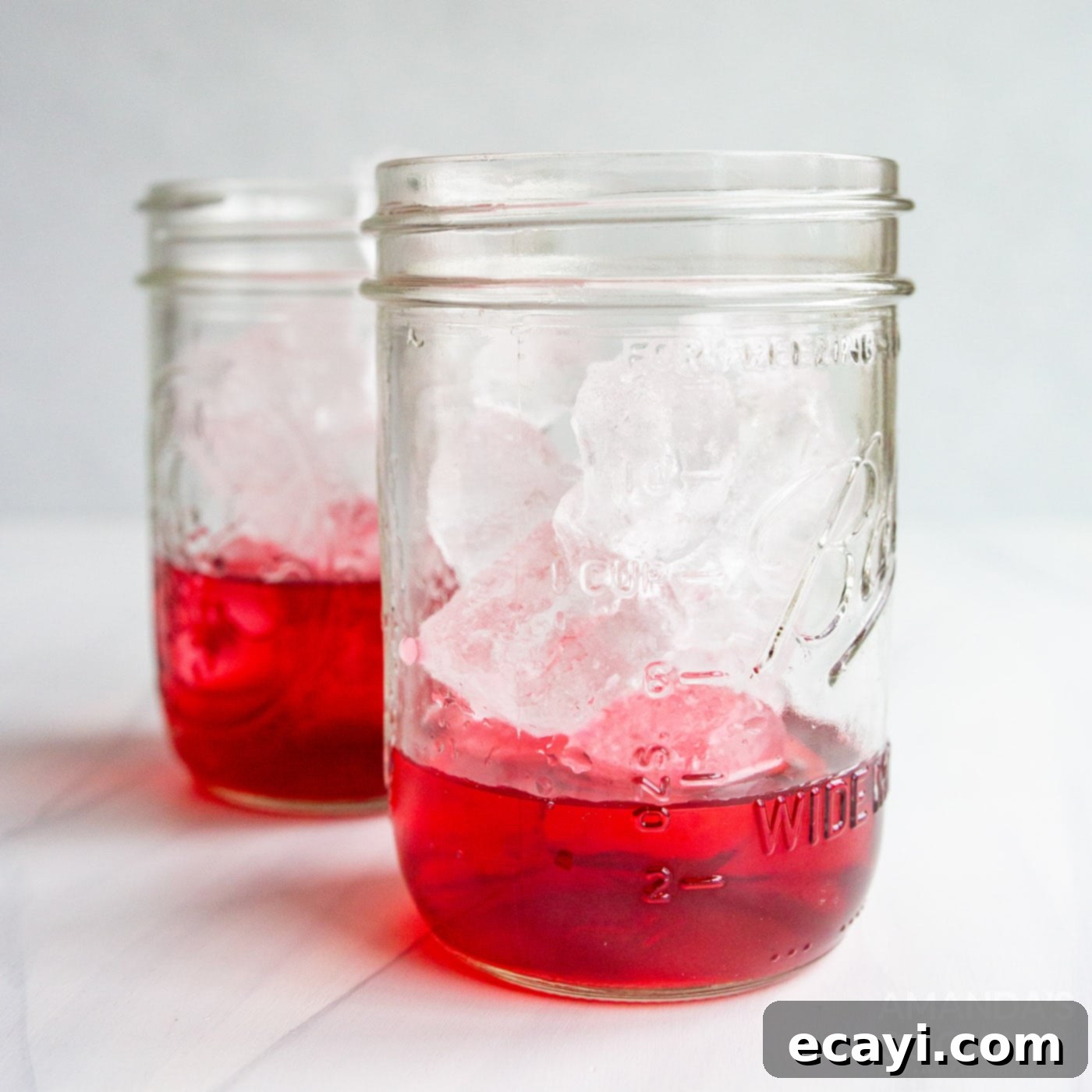 Patriot's Zeal 5 A mason jar with the first red layer of cran-raspberry juice, topped with ice, ready for the next layer of patriotic punch.