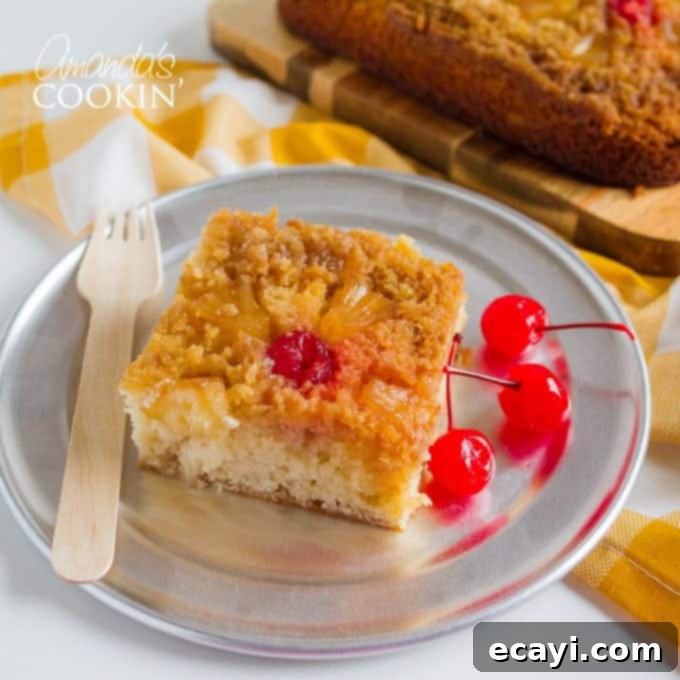 Enjoy a delicious slice of this homemade pineapple upside down cake, featuring moist yellow cake and a sweet, caramelized pineapple and cherry topping. Slice of Pineapple Upside Down Cake on a Plate