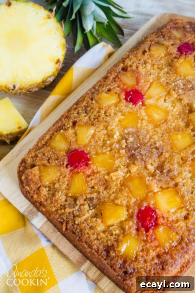 The vibrant pineapple chunks and bright red maraschino cherries are artfully arranged over the rich brown sugar and melted butter base, creating the signature look of this classic pineapple upside down cake. #caketopping #pineapplecherries #bakingdetails Detailed View of Pineapple Upside Down Cake Topping