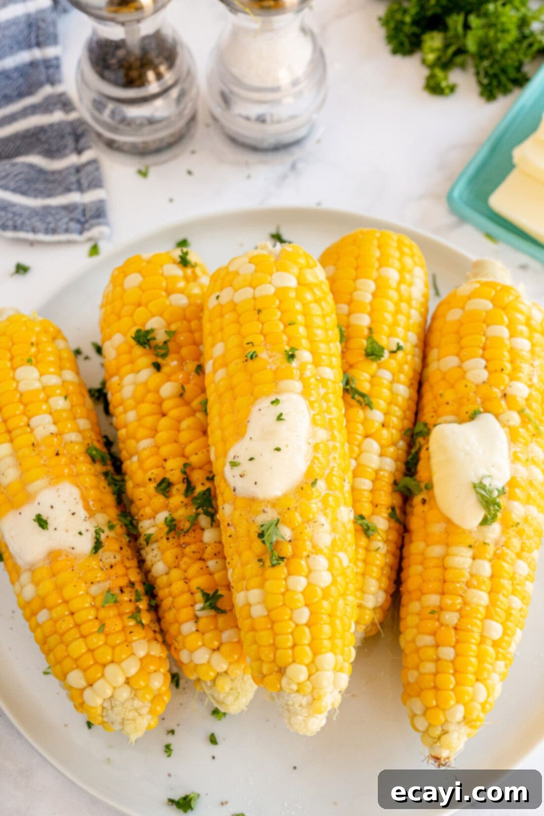 Golden Grilled Corn 10 Close-up of grilled corn on the cob with melted butter and fresh parsley