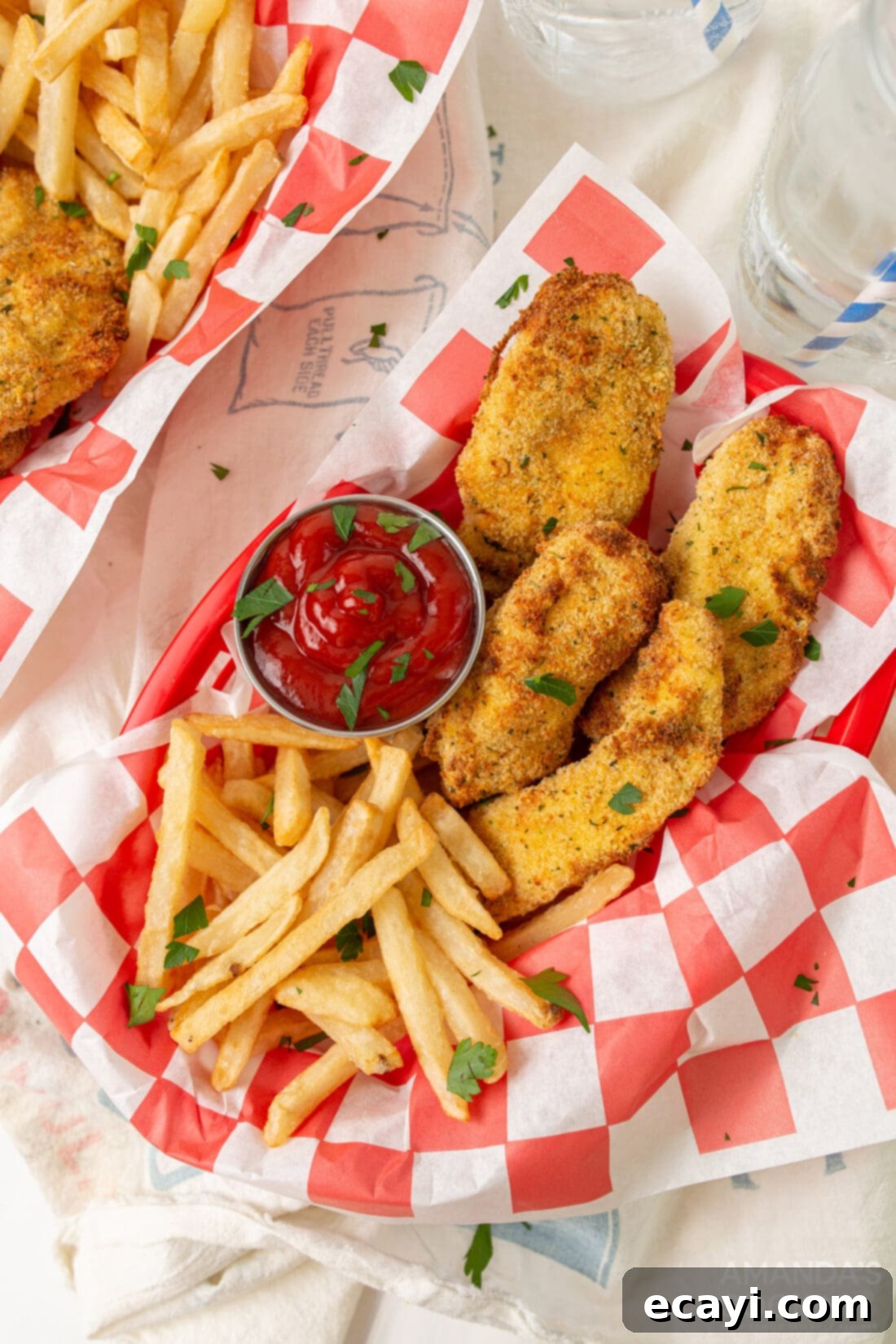 Crispy Air Fryer Chicken Tenders 2 air fryer chicken tenders in baskets with fries