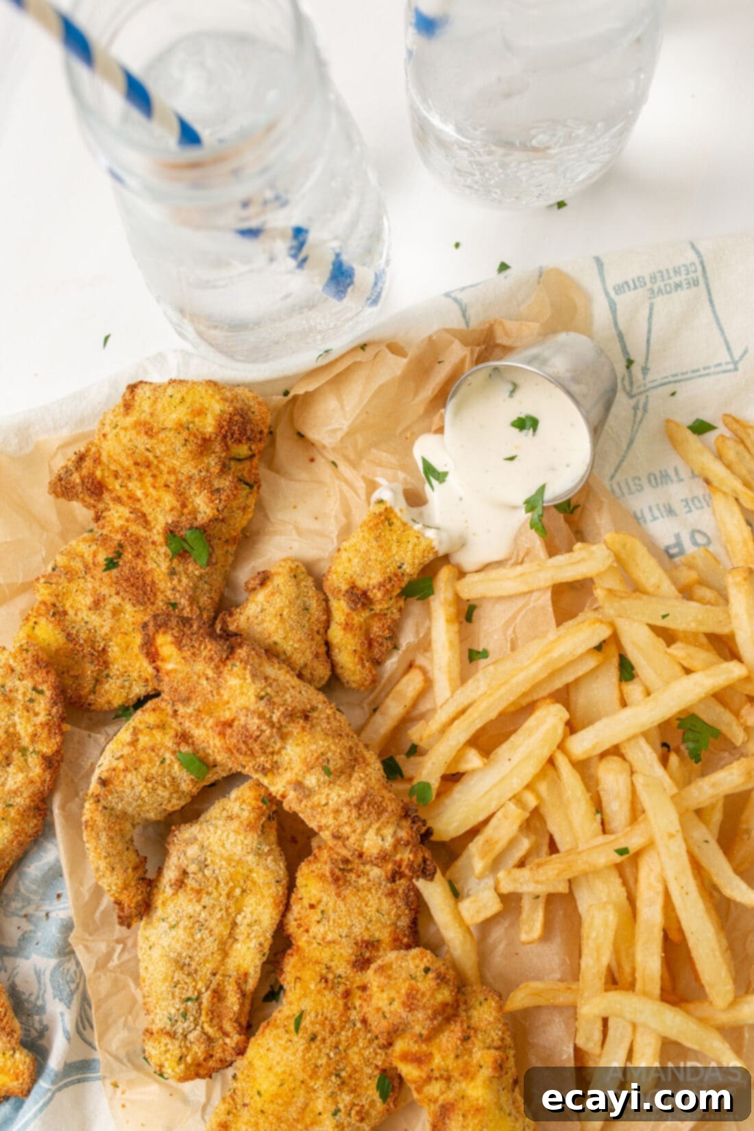 Crispy Air Fryer Chicken Tenders 3 air fryer chicken tenders with fries on parchment