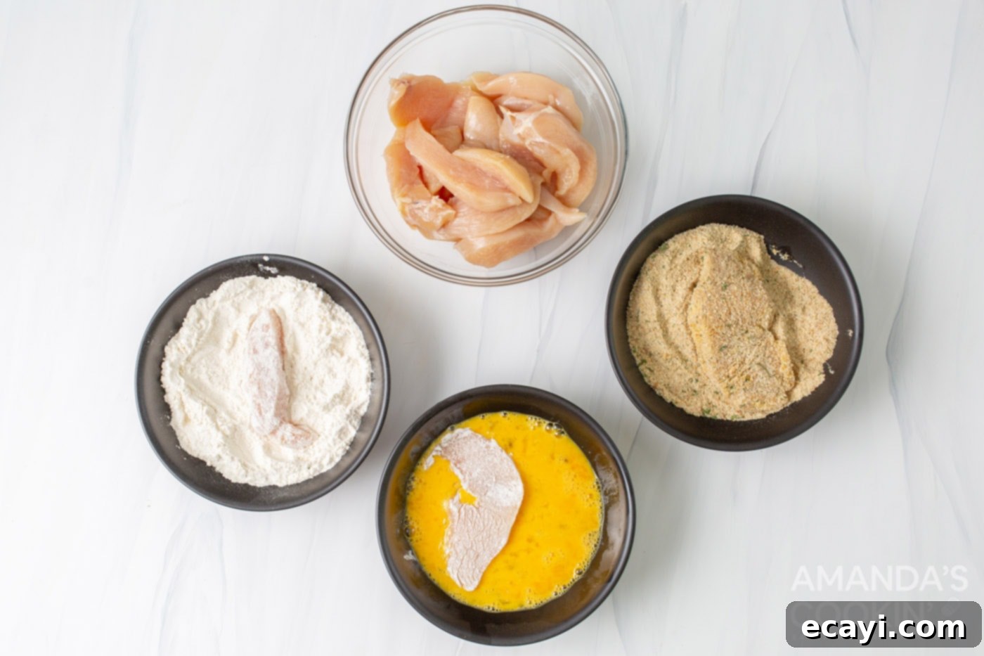 Crispy Air Fryer Chicken Tenders 5 flour, eggs,, breadcrumbs, and chicken in bowls