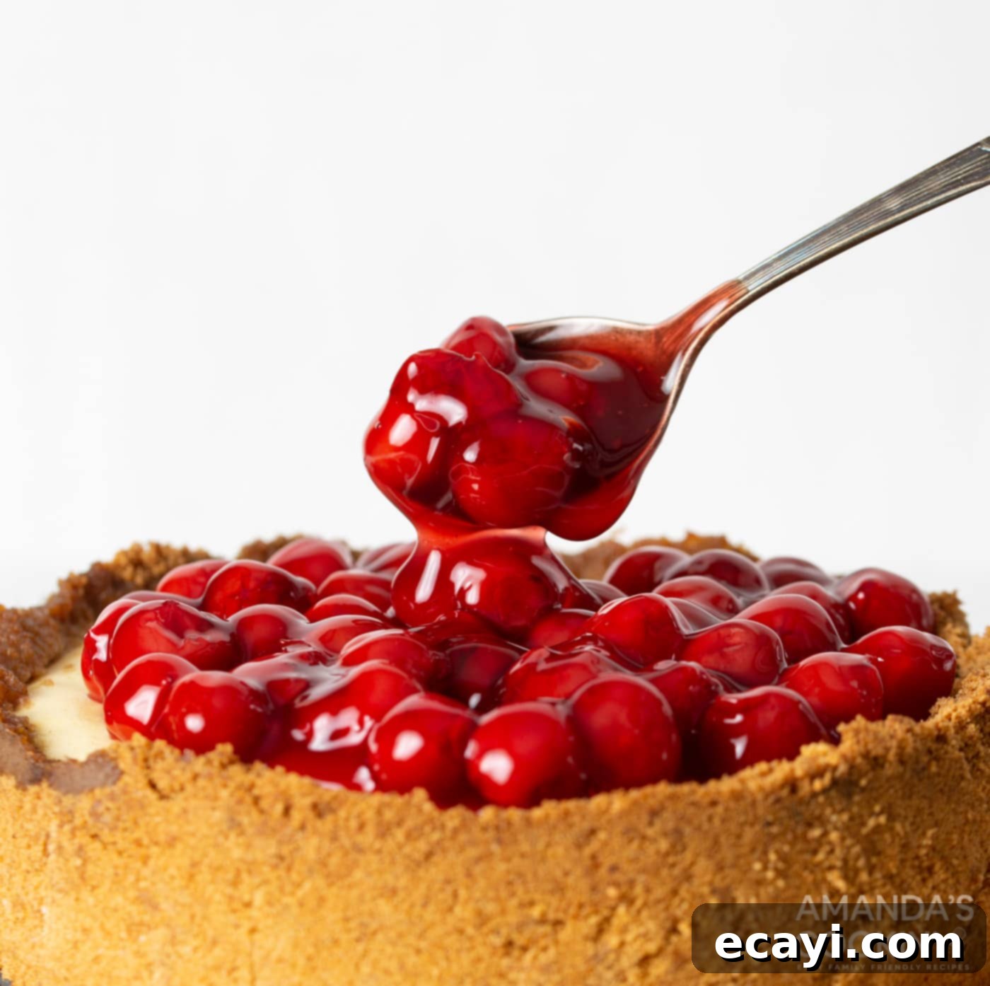 Silky Smooth Instant Pot Cheesecake 12 spoon with cherry pie filling on cheesecake