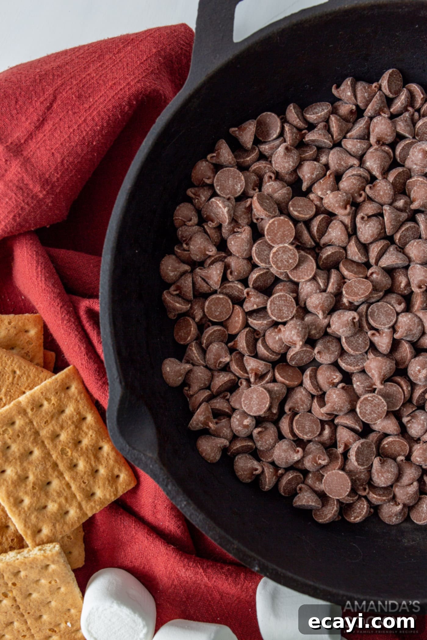 Gooey S'mores Skillet 5 Milk chocolate chips spread evenly in an 8-inch cast iron skillet, ready for melting.
