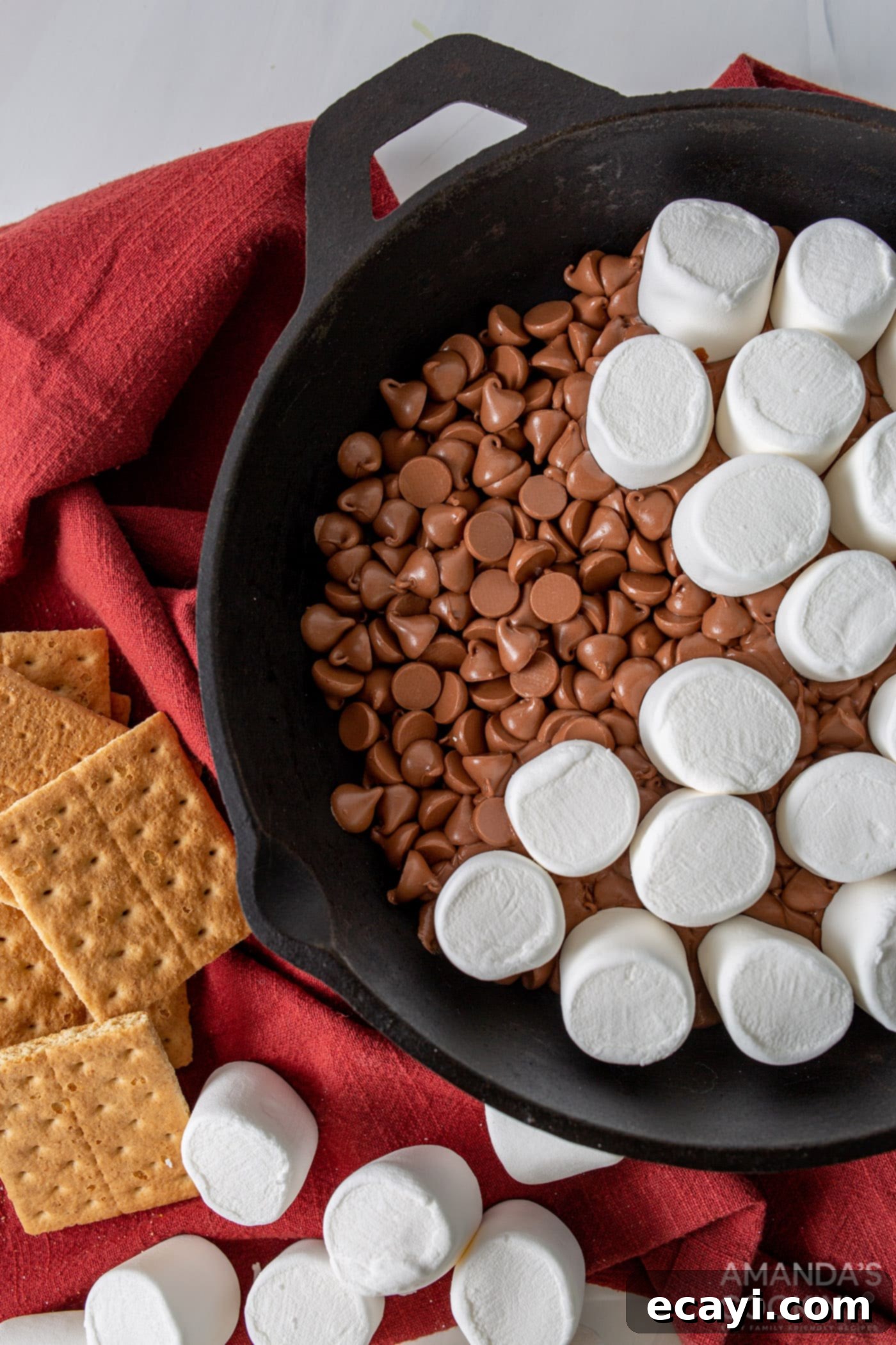 Gooey S'mores Skillet 6 Marshmallows carefully placed in concentric circles over the melted chocolate in a cast-iron skillet.