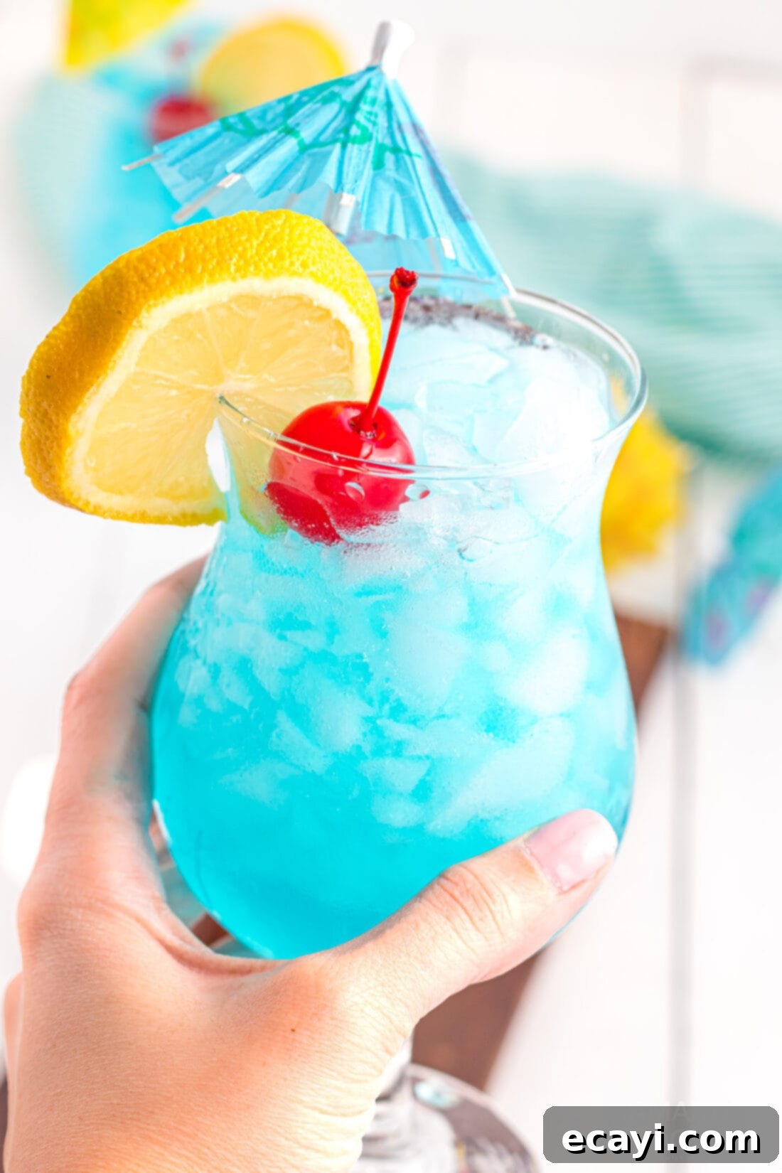 Azure Lagoon Delight 3 holding a Blue Lagoon Cocktail