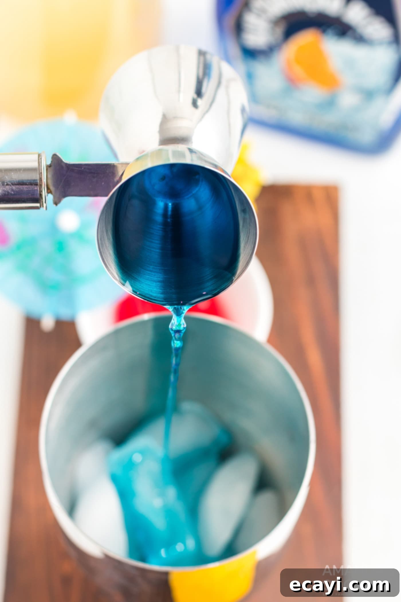 Azure Lagoon Delight 6 pouring blue Curacao into cocktail shaker with ice