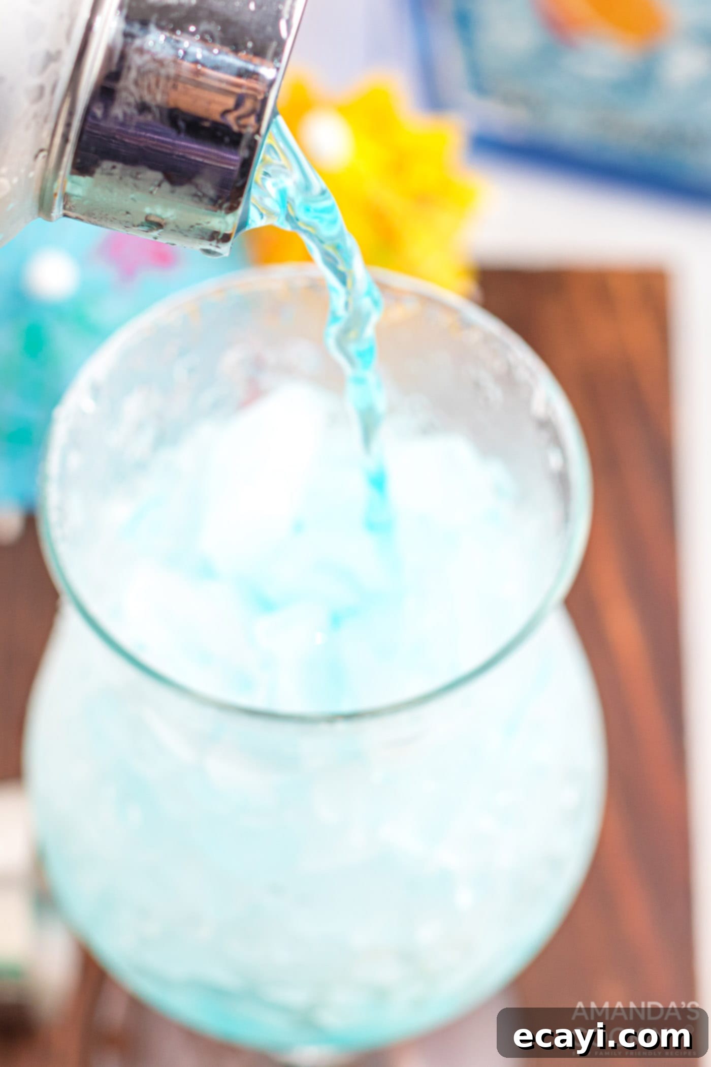 Azure Lagoon Delight 7 pouring blue lagoon cocktail into a hurricane glass