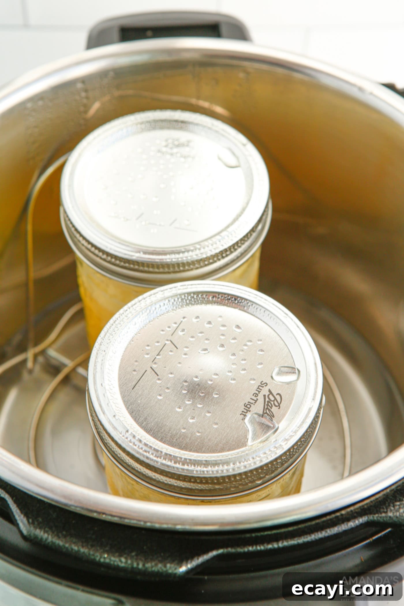 Effortless Instant Pot Lemon Curd 7 mason jars with lemon curd cooking inside an instant pot