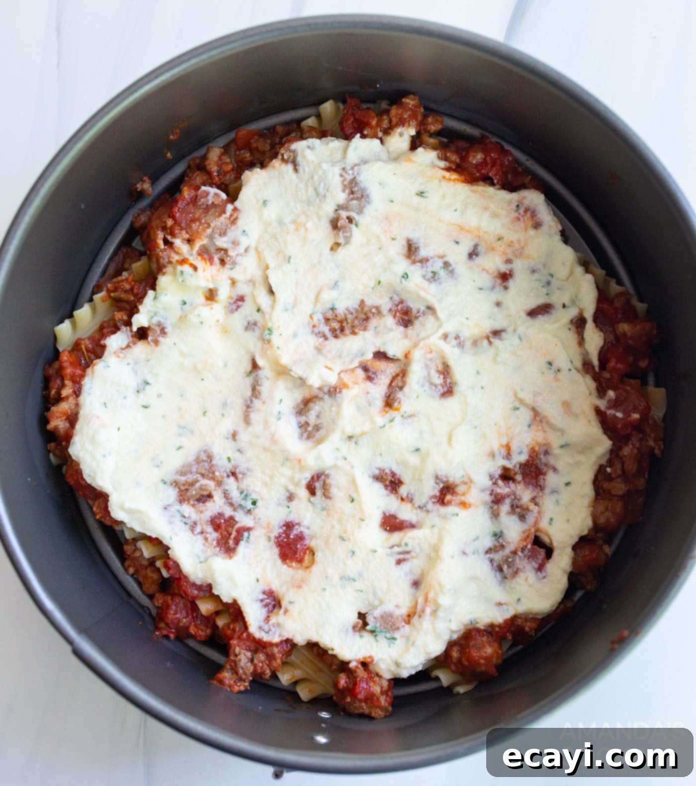 Quick Instant Pot Lasagna 9 Ricotta cheese mixture spread on top of lasagna noodles in a pan.