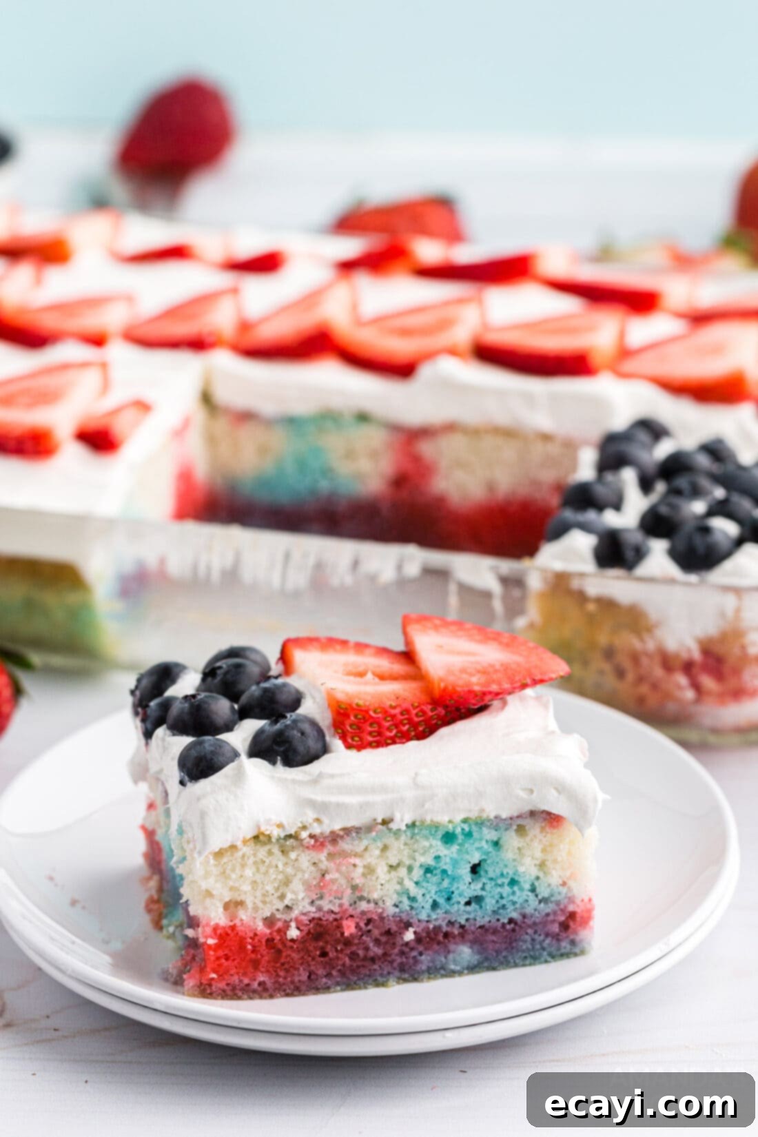 Patriotic Red, White and Blue Poke Cake 3 A perfectly sliced piece of red, white, and blue poke cake showing the colorful jello-infused layers.