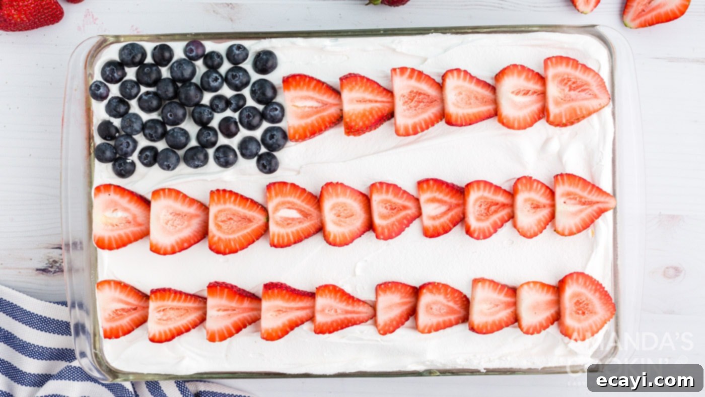 Patriotic Red, White and Blue Poke Cake 10 A fully decorated cake resembling an American flag with blueberry square and strawberry stripes.